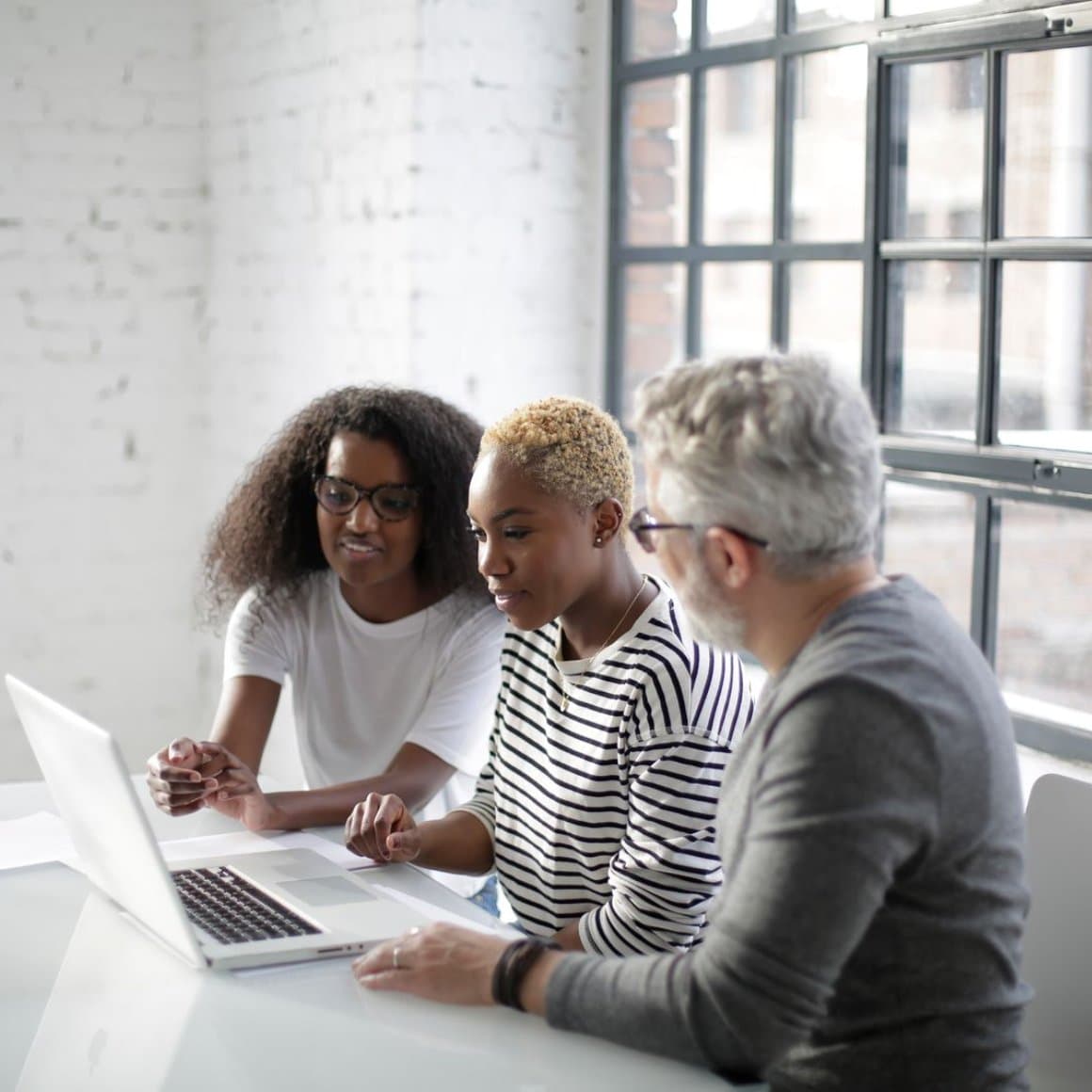 A team reviewing an email programme together on a laptop